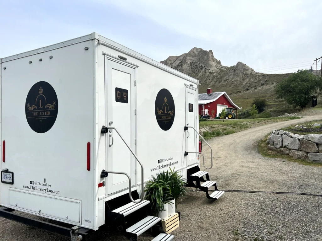 The Lux Loo luxury washroom trailer rental positioned beside an access road at a rural BC event venue